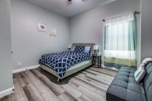1 dormitorio con cama, sofá y ventana en Cozy brand new beach house - 2 mins to the beach en Galveston