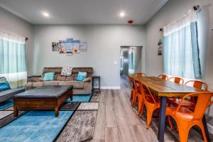 sala de estar con mesa, sillas y sofá en Cozy brand new beach house - 2 mins to the beach en Galveston
