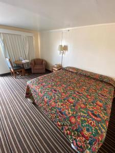 ein Hotelzimmer mit einem großen Bett mit einer bunten Decke in der Unterkunft Western inn in Tulsa