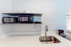 a kitchen with a sink and a microwave at Humphreys - Studio in Flagstaff