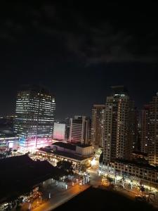 a city lit up at night with buildings at Manhattan Plaza Tower 1 in Manila