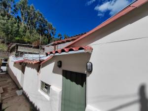 una casa blanca con una puerta verde en el lateral en Centro Cusco Inti en Cusco