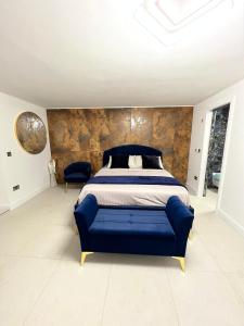a bedroom with a blue bed and a wall at Garden View in Northfleet