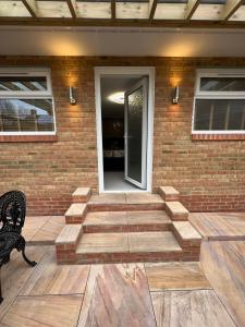 a patio with a bench and a brick wall at Garden View in Northfleet