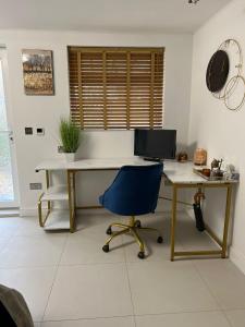 a desk with a computer and a chair in a room at Garden View in Northfleet