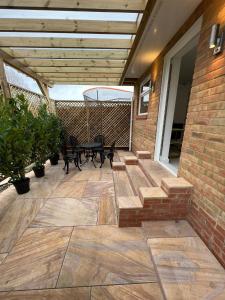 a patio with benches and tables on a brick building at Garden View in Northfleet