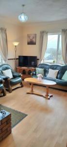 a living room with a couch and a table at Havana Holiday Cottage Inishowen 