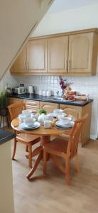 a kitchen with a wooden table and chairs and a table and chairsktop at Havana Holiday Cottage Inishowen 