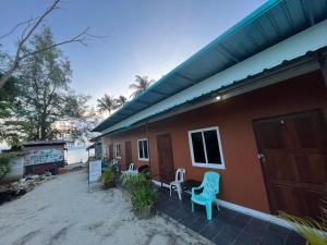 a house on the beach with two blue chairs outside at Phangan Dream box in Baan Tai