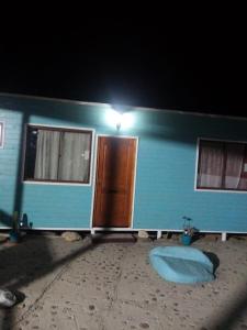 ein blaues Haus mit Licht an der Tür in der Nacht in der Unterkunft Cabaña florencia in Coquimbo