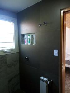 baño con cabina de ducha y ventana en El Remanso, los cocos en Los Cocos