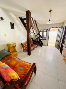 sala de estar con cama y escalera en Casa de ferias pé na areia en Arraial do Cabo