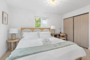 a bedroom with a large white bed with two towels at @ Marbella Lane - Fresh and Vibrant 3BR Home in San Jose