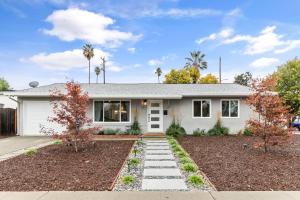 a white house with palm trees in front of it at @ Marbella Lane - Fresh and Vibrant 3BR Home in San Jose