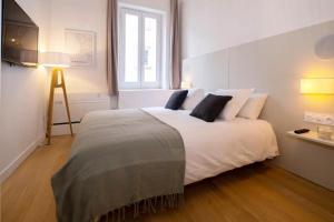 1 dormitorio con 1 cama blanca grande y 2 almohadas en Design Suites Vieux Port, en Marsella