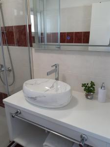 a white sink on a counter in a bathroom at Apartment Pag 16100c in Pag +14 photos