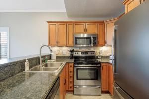 a kitchen with stainless steel appliances and wooden cabinets at Emerald Bay Unit 1B in Lake Ozark