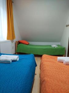 una camera con due letti con lenzuola verdi e arancioni di Stašina vikendica Divčibare a Divčibare