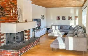 a living room with a couch and a fireplace at Beautiful Home In Kollungtveit With Wifi And 5 Bedrooms 