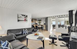 a living room with a couch and a table at Nice Home In Hvide Sande With 4 Bedrooms And Wifi in Nørre Lyngvig