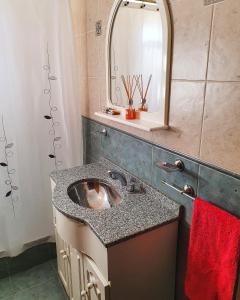 y baño con lavabo y espejo. en Cabañas Andaluhe en Villa Carlos Paz
