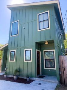 una casa verde con puerta delantera y ventanas en Secret Garden en San Antonio