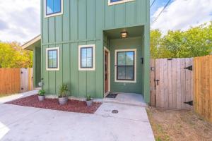 une maison verte avec une clôture devant elle dans l'établissement Secret Garden, à San Antonio