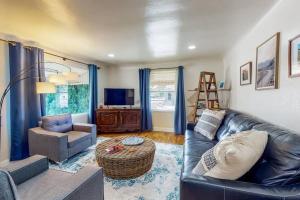 a living room with a leather couch and a chair at Charming! King bed, W/D, A/C, Garage in Twin Falls