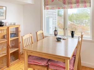 HenånにあるHoliday home HENÅN VIIの窓付きのキッチン(木製テーブル、椅子付)