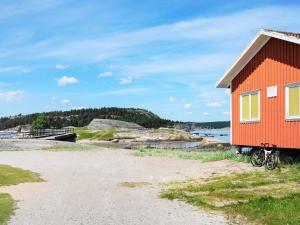 HenånにあるHoliday home HENÅN VIIの水車の横に停めた自転車付き赤い家