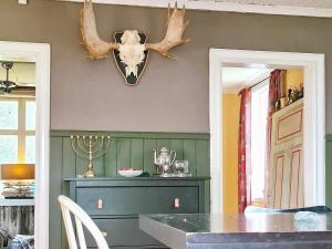 a dining room with a table and antlers on the wall at Holiday home BJURHOLM II in Bjurholm
