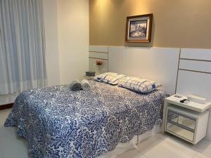 a bedroom with a bed with a blue and white blanket at CASA CONDOMÍNIO IBEROSTATE - RESORT IBEROSTAR in Praia do Forte