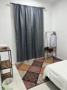 una camera con letto e tenda grigia di Aaira Guest House Melaka a Malacca