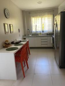 プライア・ド・フォルテにあるCASA CONDOMÍNIO IBEROSTATE - RESORT IBEROSTARのキッチン(冷蔵庫、テーブル、椅子付)