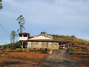 una casa en una colina con un camino de tierra en Tranquil Ridge Hilltop Bungalow, en Hatton