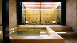 a bath tub in a room with a window at Hotel Isago Kobe in Kobe