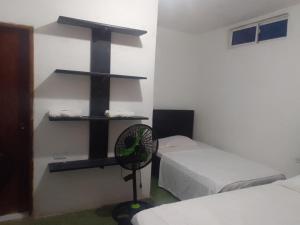 a room with two beds and a fan on a wall at Tadù Playa Hotel in San Bernardo del Viento