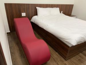 a red bench next to a bed in a room at Adal Motel in Kiến An