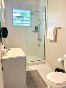 a bathroom with a shower and a sink and a toilet at Breathtaking 2-Bedroom Beachside Apartment in San Juan