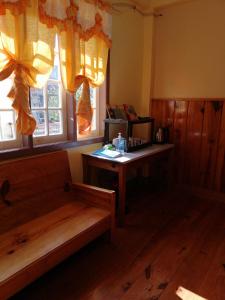 een kamer met een bank, een tafel en ramen bij Inn Maugay Bed and Bath in Sagada