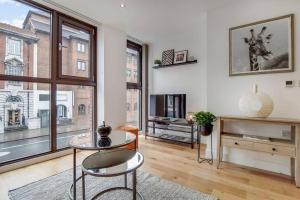 a living room with a glass table and a tv at BR2 - Stunning 1 Bed Apartment Heart of Borough in London