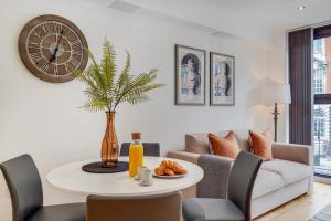 a living room with a table and a clock on the wall at BR2 - Stunning 1 Bed Apartment Heart of Borough in London