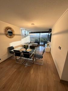 een woonkamer met een tafel en stoelen en een bank bij Confortable Departamento VLC in Santiago