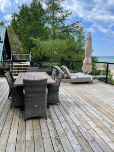 a wooden deck with a table and chairs and an umbrella at Home of the Living Sunset in Miller Lake