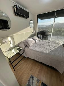 1 dormitorio con cama y mesa de cristal con ventana en Confortable Departamento VLC, en Santiago