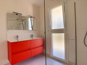 a bathroom with a red cabinet and a mirror at Maison Crozon, 4 pièces, 6 personnes - FR-1-370-37 in Crozon