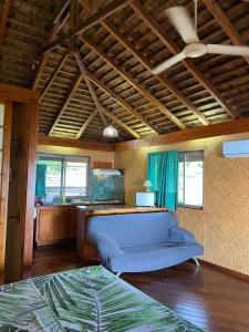 a bedroom with a blue bed in a room at Tehuarupe Surf Studios in Haapiti