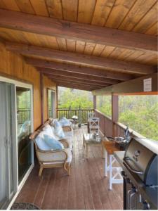 a screened in porch with a couch and chairs at Serenity Hale in Papa Bay Estates