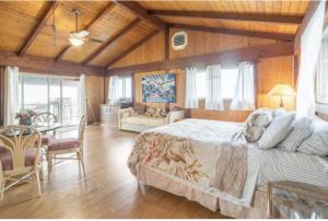 a bedroom with a large bed and a dining room at Serenity Hale in Papa Bay Estates