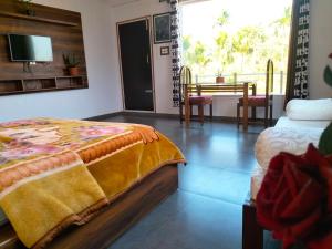 a bedroom with a bed and a table with chairs at Samith Home Stay in Madikeri